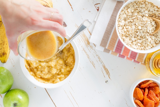 Granola preparation, white wood background