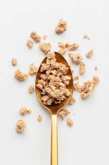 Granola on spoon on light background