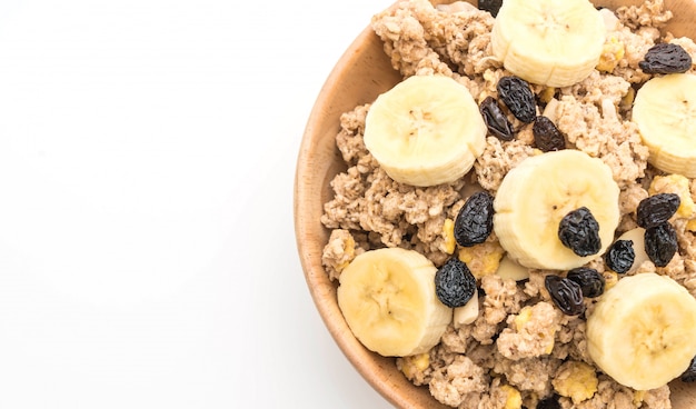 granola with banana, raisin and milk for breakfast