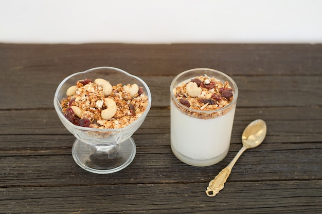 Photo granola with berries and yogurt on wooden table. traditional american breakfast