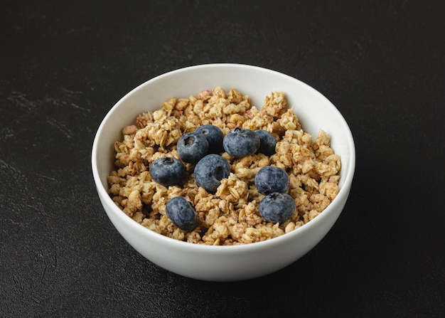 Granola with blueberry in white bowl