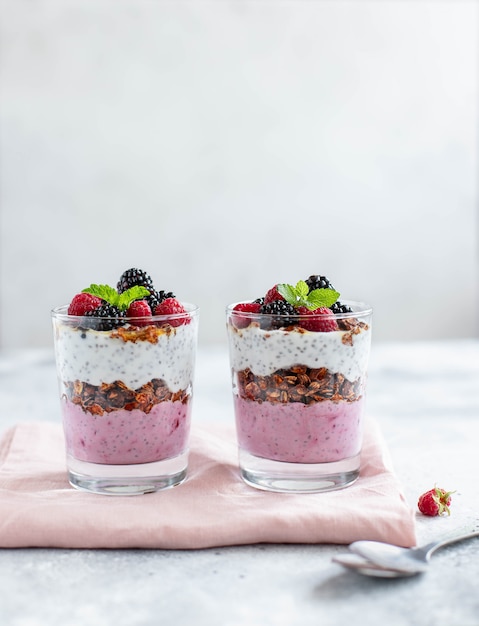 Granola with chia yogurt and fresh berries on a light background