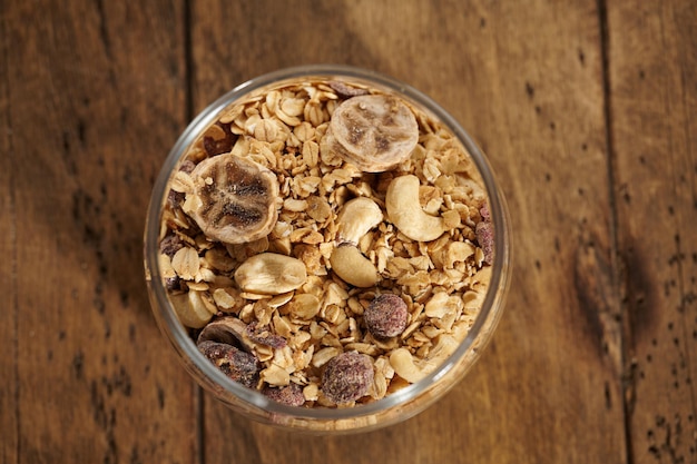 Foto muesli con frutta secca in un barattolo su un tavolo di legno