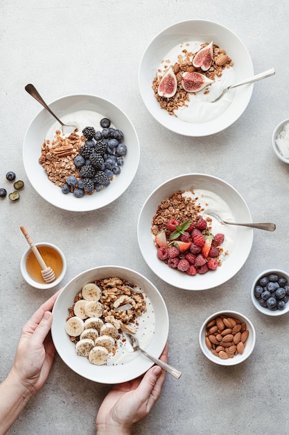 Granola with yogurt berries fruits and nuts on a concrete background top view