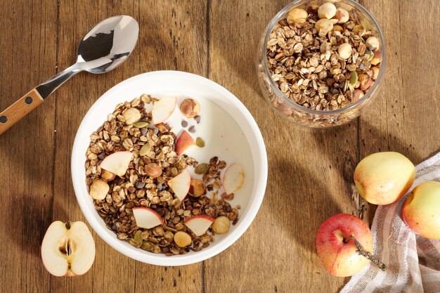 Muesli con yogurt e frutti di bosco in una ciotola bianca su un tavolo di legno