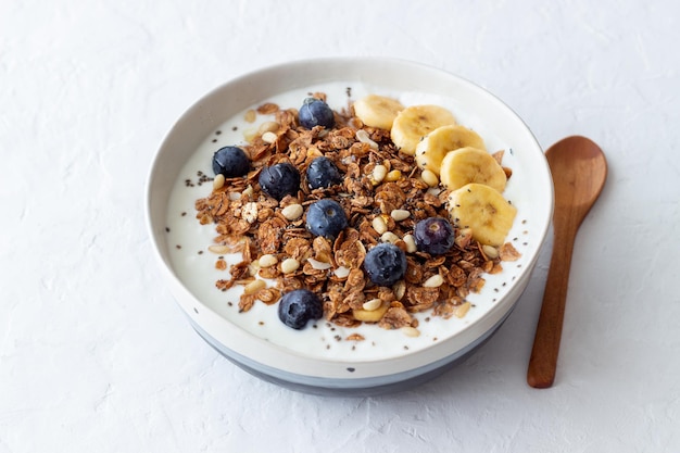 Granola with yogurt, blueberries, nuts, banana and honey. Muesli. Healthy eating. Vegetarian food.