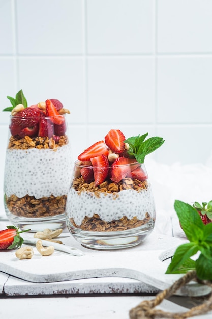 Granola with yogurt chia and strawberries in a glass on a white background