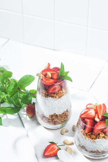 Granola with yogurt chia and strawberries in a glass on a white background