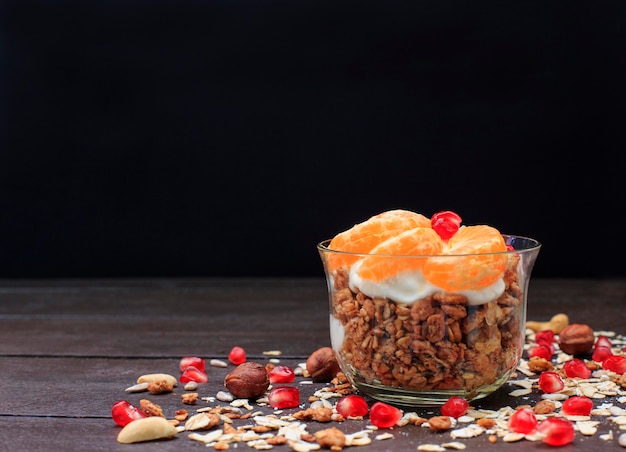 Granola with yogurt and fruits in small glass. 