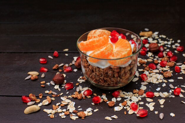 Granola with yogurt and fruits in small glass. 