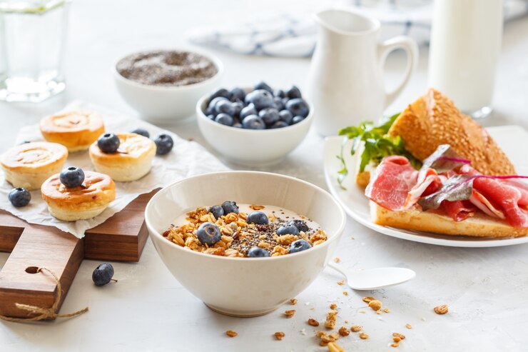 Photo granola with yogurt, sandwiches with meat and avocado, and mini cheesecakes