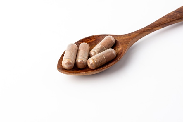 Grape extract powder capsule on wooden spoon