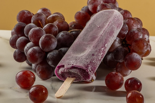 Grape ice cream on bunches of grapes on white background