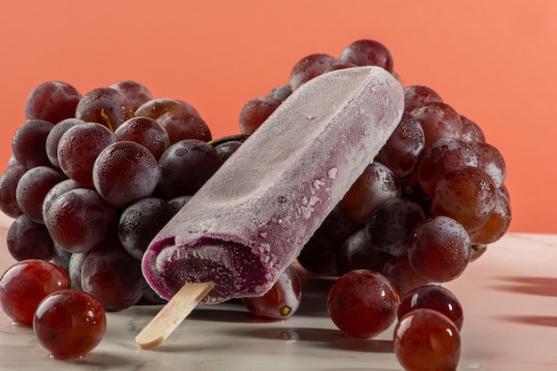 Grape ice cream on bunches of grapes on white background