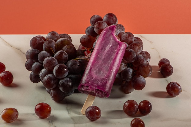 Grape ice cream on bunches of grapes on white background