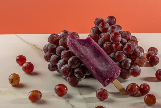 Photo grape ice cream on bunches of grapes on white background