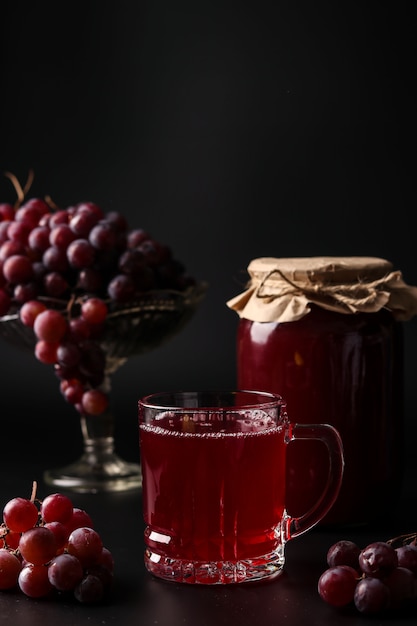 Grape juice in a glass and a cans, cooked in a juicer, harvesting juice from a grape harvest