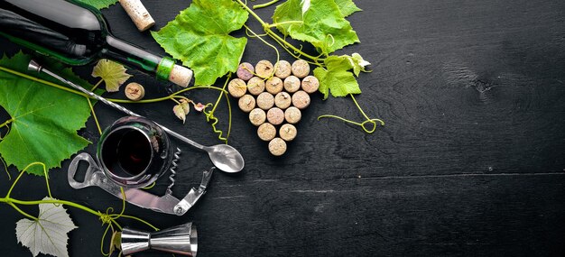 Grape motive. A bottle and a glass of wine and grape leaves. Top view. Free space.