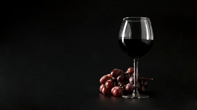 写真 ワインのガラスの近くのブドウ