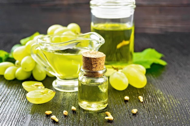 Olio d'uva in una bottiglia, salsiera e un barattolo, bacche di uva verde