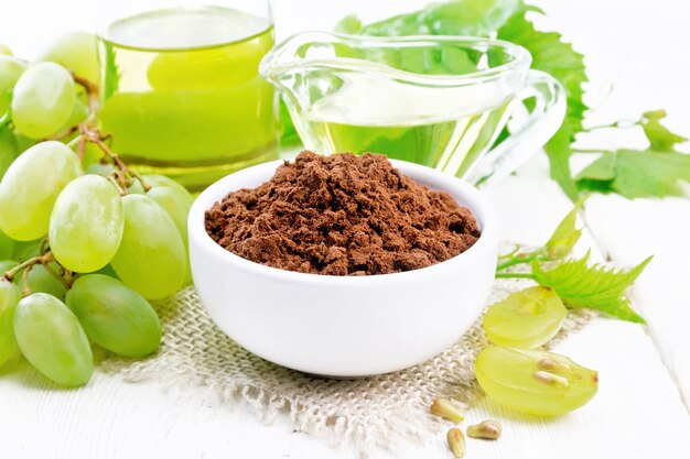 Grape seed flour in a bowl on sacking, oil in a jar and gravy boat