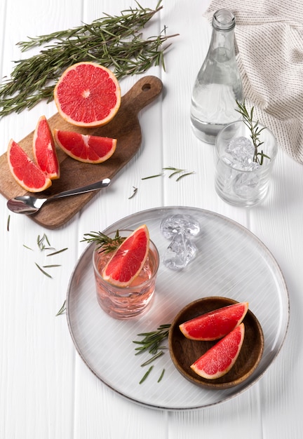 Grapefruit cocktail with rosemary on white wooden table