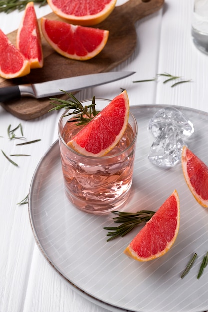 Grapefruit cocktail with rosemary on white wooden table