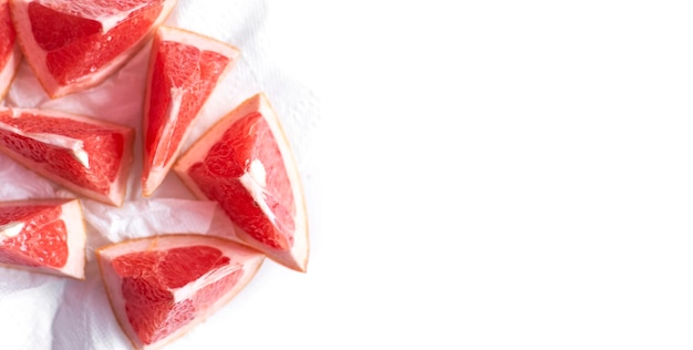 Grapefruit cut in pieces on white background Copy space