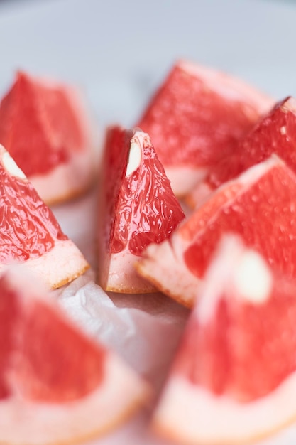 Grapefruit cut in pieces on white background