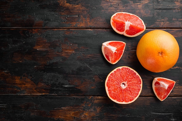 Grapefruit cuts set, on old dark  wooden table background, top view flat lay, with copy space for text