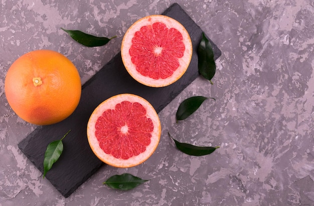 Grapefruit and grapefruit wedges on a gray background Flat lay Copy space