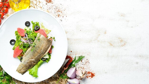 Grapefruit groentesalade en forelfilet op een bord Bovenaanzicht vrije ruimte voor uw tekst Rustieke stijl