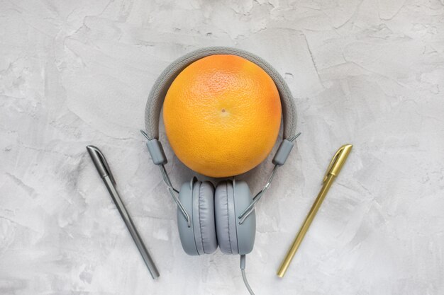 Grapefruit and headphones on gray