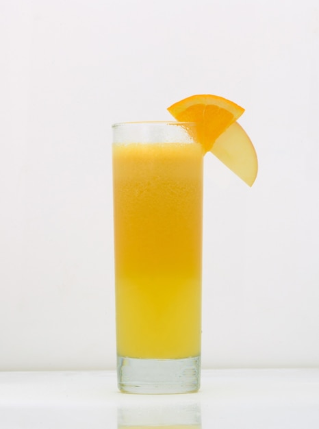 Succo di pompelmo in un bicchiere con una fetta di arancia e mela. bere isolato su sfondo bianco