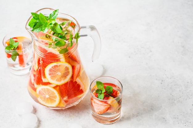 Limonata al pompelmo con limone e menta in caraffa di vetro.