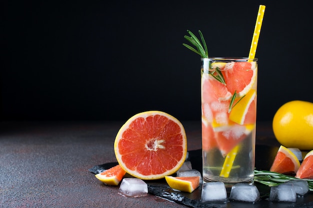 Grapefruit limonade. Twee glazen verfrissend drankje, water met grapefruit, rozemarijntakken en ijs. Receptconcept, cocktail