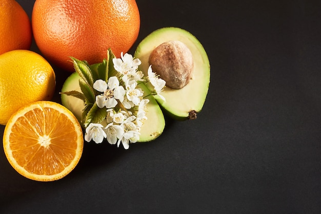 Grapefruit, orange and avocado, isolated on a black.