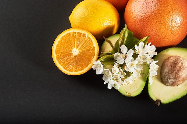 Grapefruit, orange and avocado, isolated on a black.