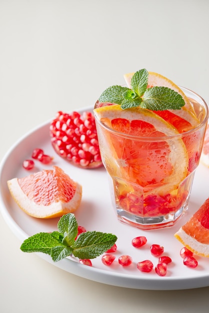 Grapefruit and pomegranate cocktail or mocktail refreshing summer drink with crushed ice and sparkling water