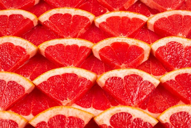 Grapefruit red juicy slices background. top view.