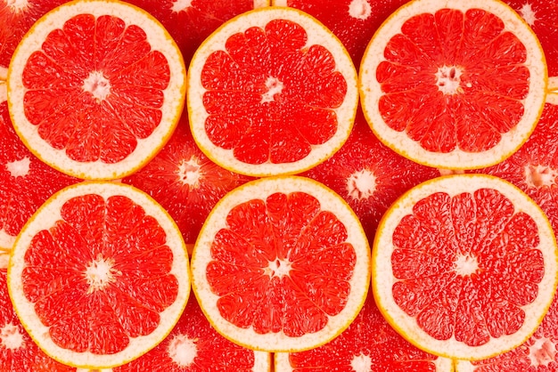 Photo grapefruit red juicy slices background. top view