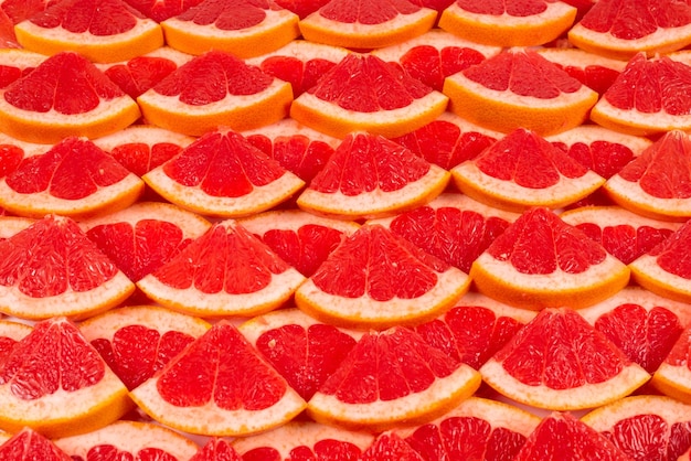 Grapefruit red juicy slices background. top view.