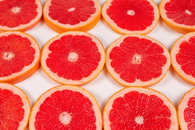 Grapefruit red juicy slices background top view