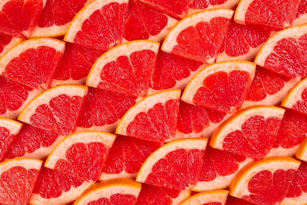 Grapefruit red juicy slices background top view