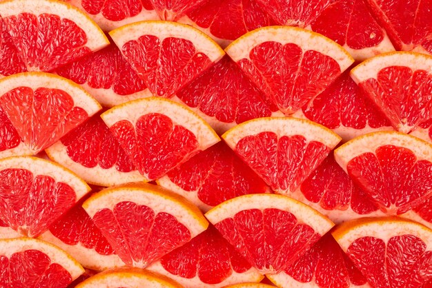 Grapefruit red juicy slices background. top view.