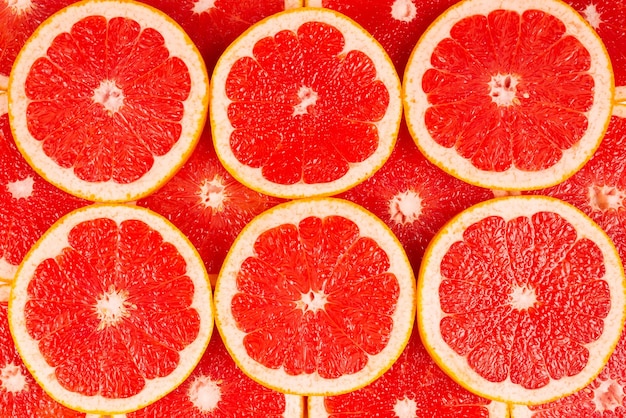 Grapefruit rode sappige plakjes achtergrond. bovenaanzicht
