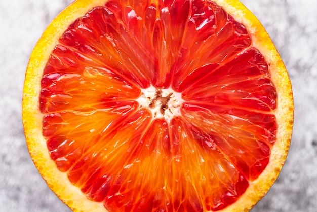 Photo grapefruit slice on grey background macro view