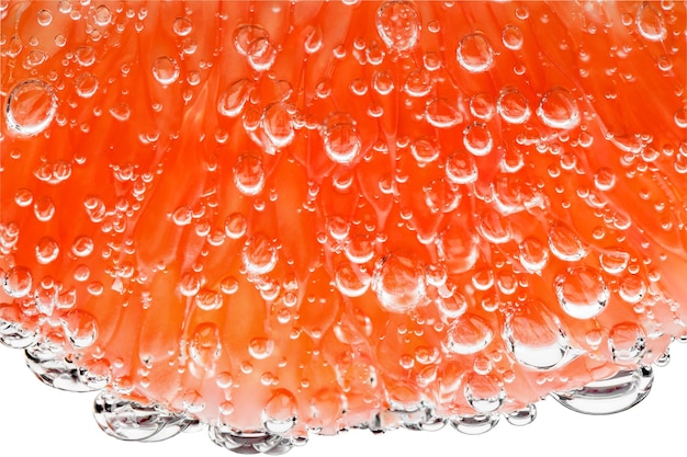 Grapefruit slice peeled in water with air bubbles in background light closeup isolated white background clipping path