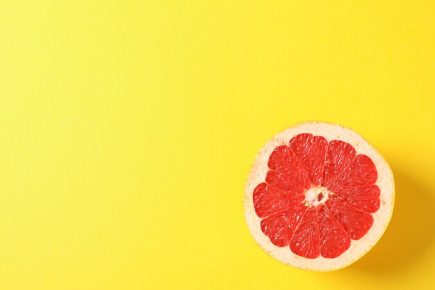 Grapefruit slice on yellow space for text