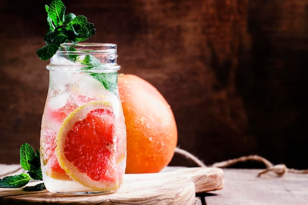 Grapefruit soda water met ijs en muntblaadjes vintage houten achtergrond selectieve aandacht